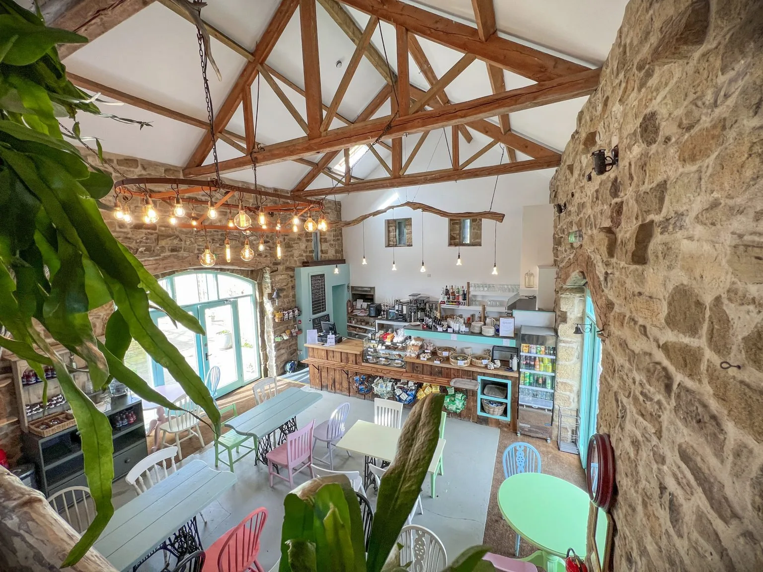 Inside the Bivouac Café, with a counter, exposed timber roof and stone walls