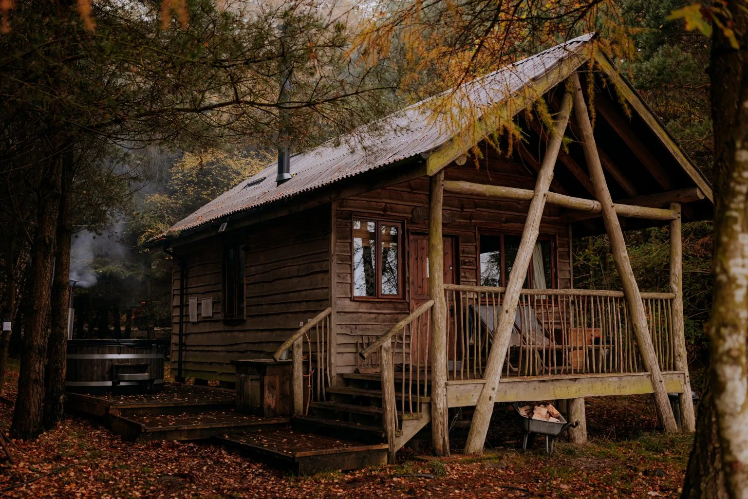 A timber Tree Lodge with a veranda among the trees at Swinton Bivouac
