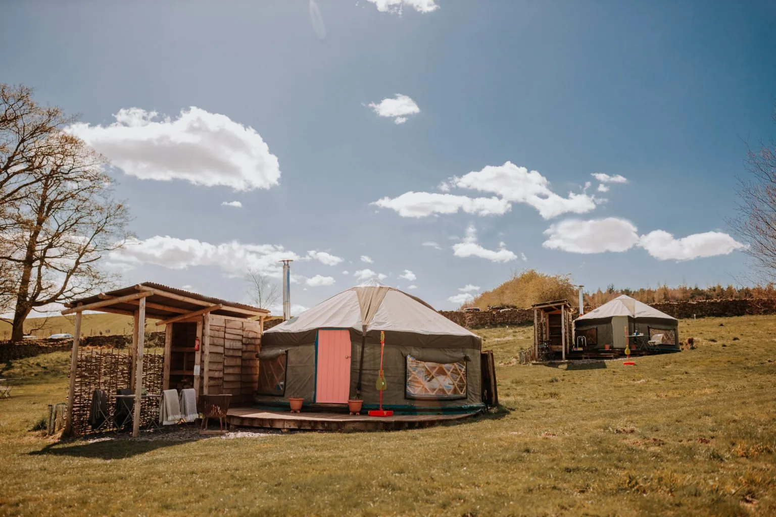 Meadow Yurts in the wildflower meadow at Swinton Bivouac under a blue sky