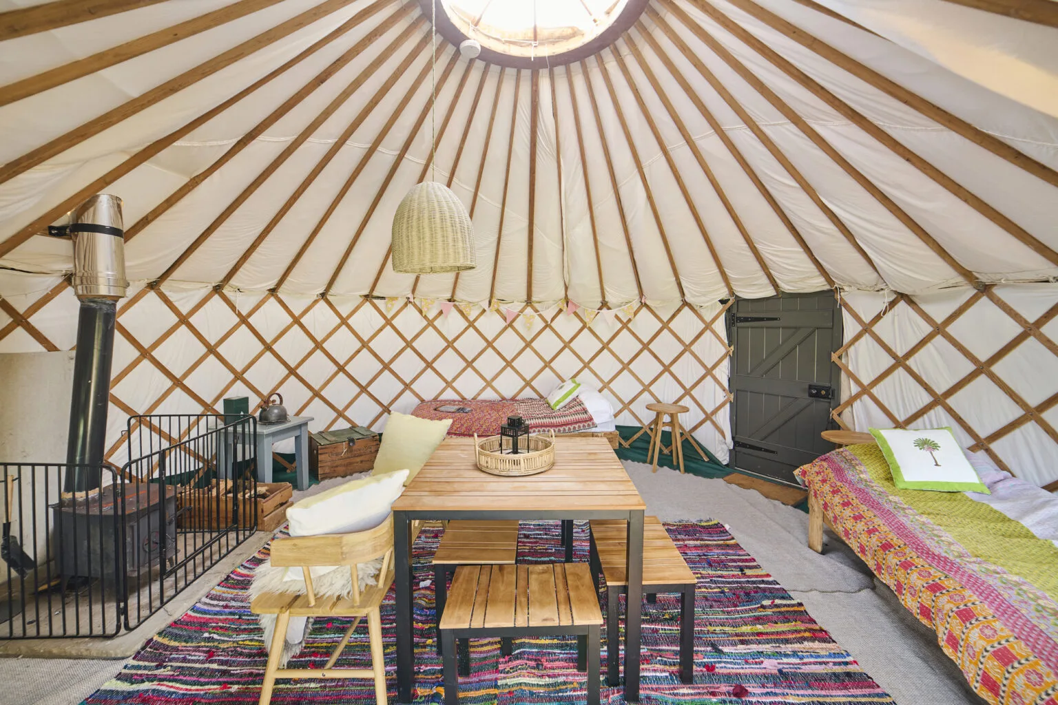 Inside a yurt, with a stove, table and seating