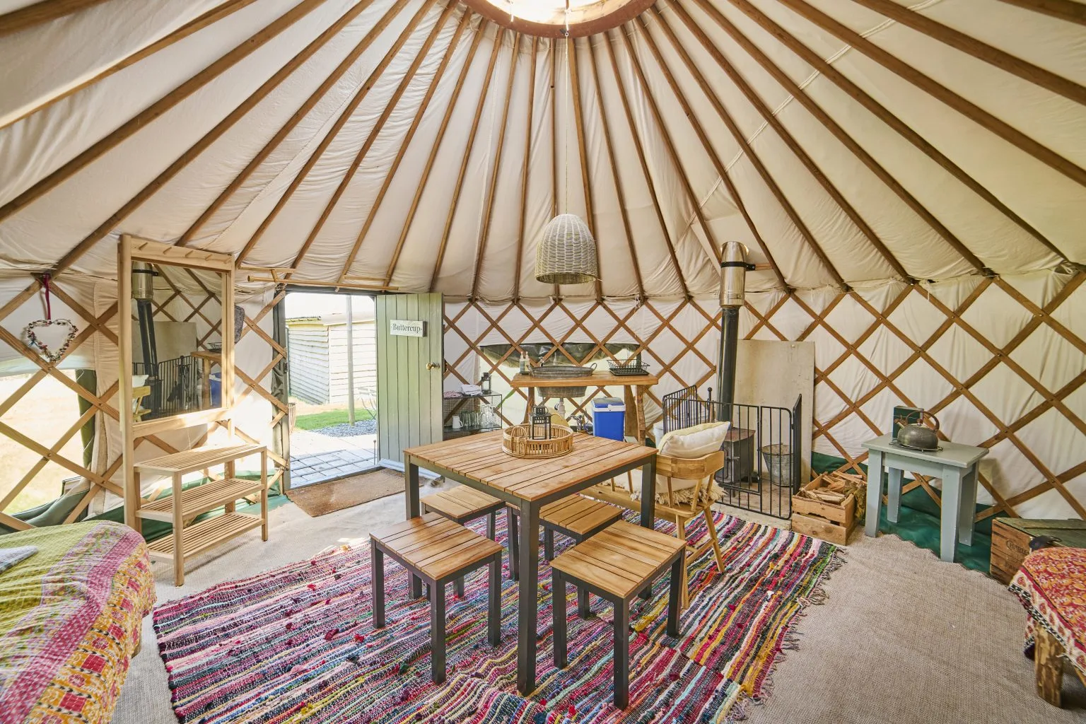 A Cabin Yurt interior with a dining table and a view through the open door