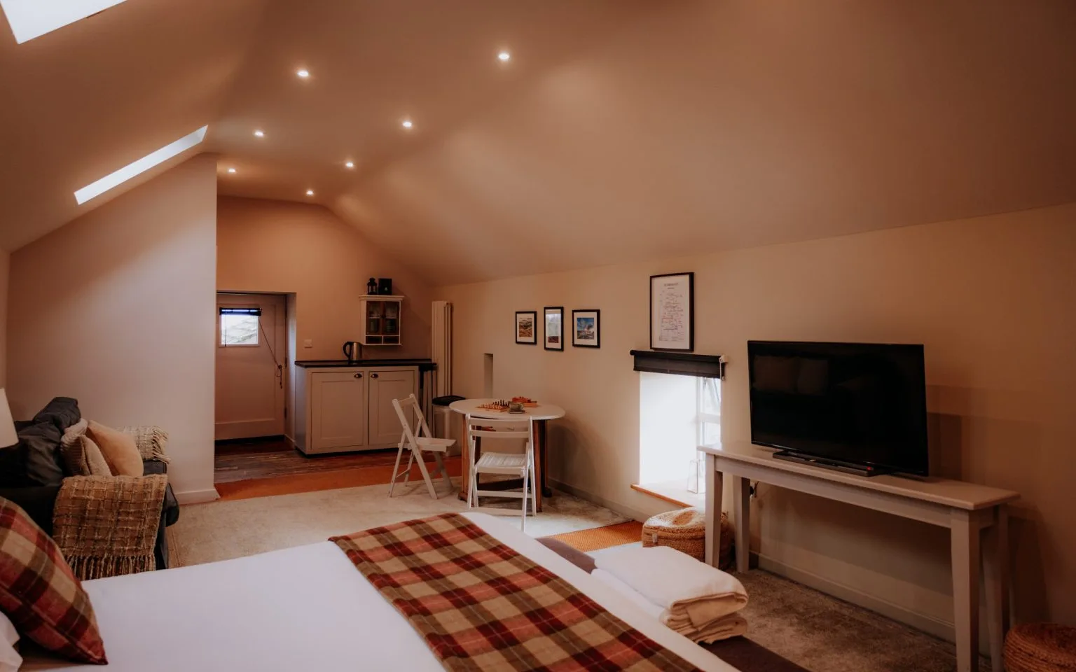 The living area of The Loft, with sofa, television and kitchenette
